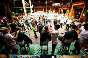 Head shaving event with individuals on a stage with large crowd