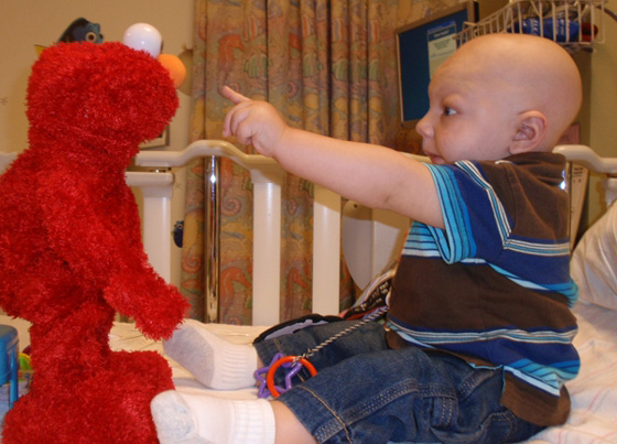 Ben giggles at Elmo during a hospital stay.