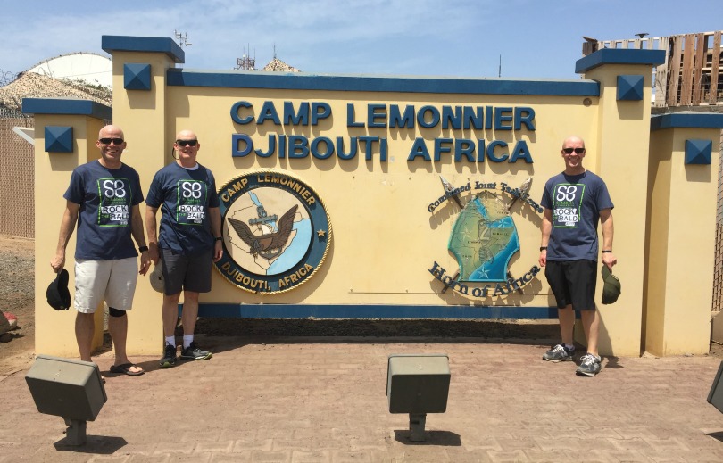 Dr. John York with his fellow shavees in front of the Djibouti sign